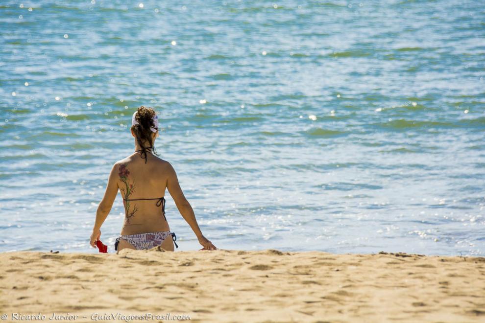 Imagem de uma moça andando em direção ao mar.